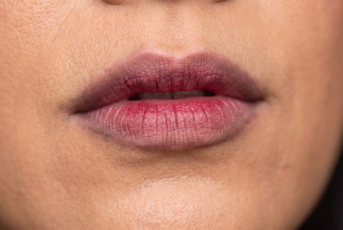 Berry lip tint dabbed only on the inner half of both lips, the outer edges still bare