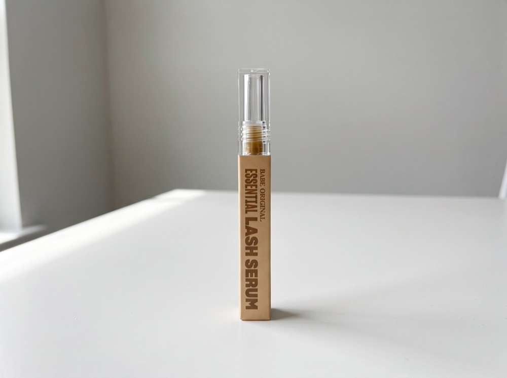 Babe Original Essential Lash Serum standing on a white tabletop