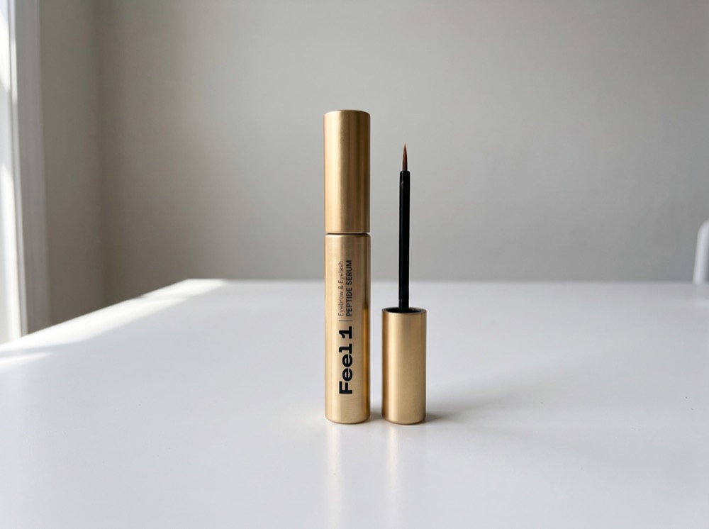 Feel1 Eyelash and Eyebrow Peptide Serum standing on a white tabletop