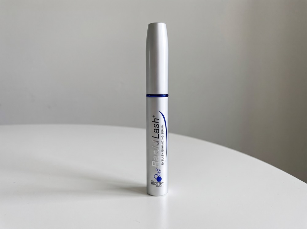 RapidLash Eyelash Enhancing Serum standing on a white tabletop