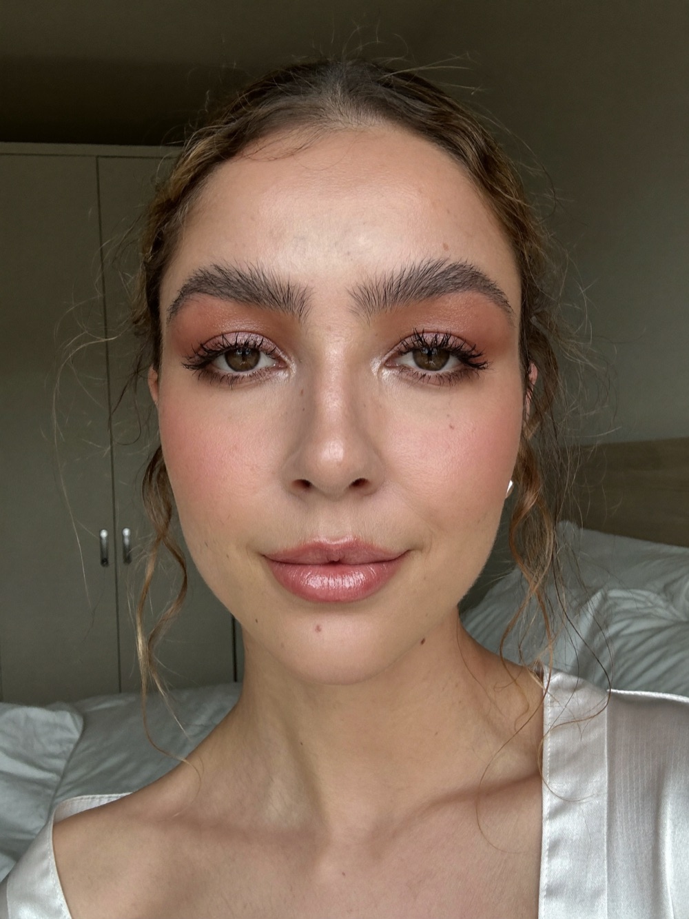 Bride with luminous skin and soft brown eye makeup photographed in daylight